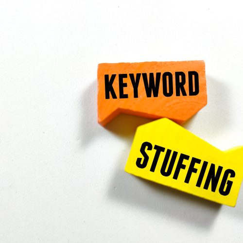 Text KEYWORD STUFFING writing on colored block on white background.